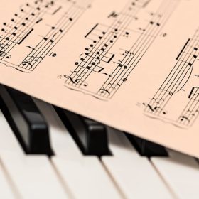 Spartito musicale posto sopra la tastiera di un pianoforte