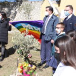 Il Sindaco, il Dirigente Scolastico, l'assessore all'istruzione in posa con la bandiera della pace su una pianta di ulivo